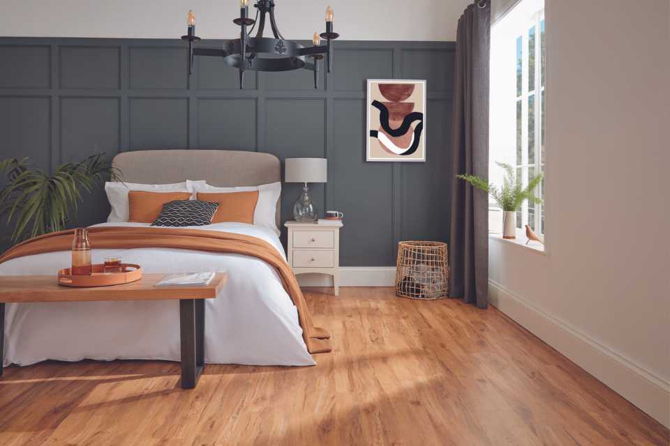 honey toned natural wood look luxury vinyl in modern bedroom with mid century accents